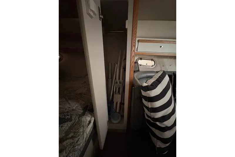 Slide: The Image of Interior of 1999 Four Winns 328 Vista boat with striped cushion and storage area. - 27