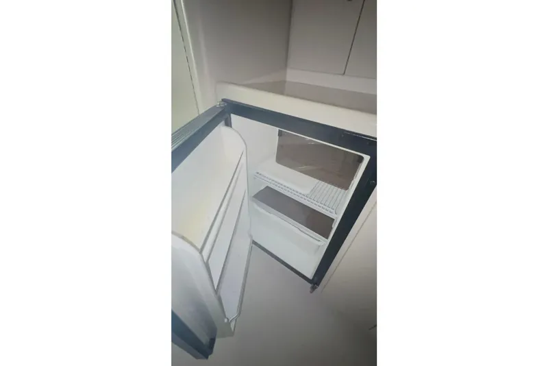 Slide: The Image of Open refrigerator inside 1999 Four Winns 328 Vista boat, showcasing interior shelves. - 30