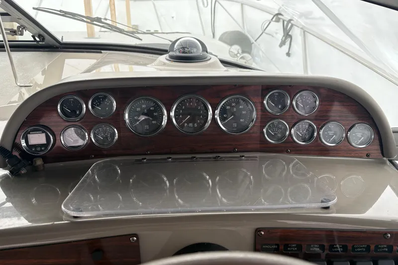 Slide: The Image of 1999 Four Winns 328 Vista dashboard with gauges and controls, featuring a classic wood finish. - 42