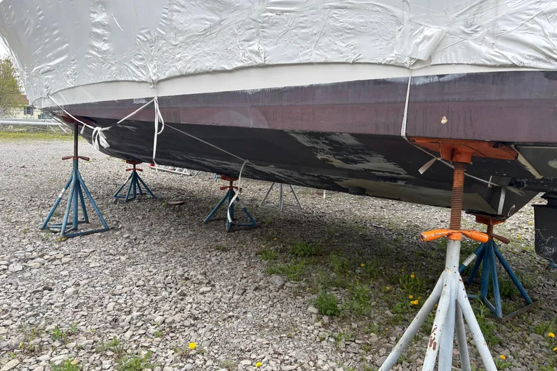 Slide: The Image of 1999 Four Winns 328 Vista boat on stands, covered and stored on gravel. - 50