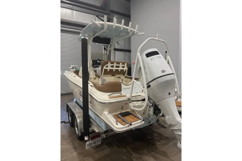 Slide: The Image of 2023 Pioneer 202 Islander boat with outboard motor on trailer in a garage. - 4