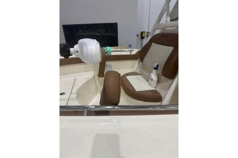 Slide: The Image of 2023 Pioneer 202 Islander boat interior with brown and white seating, featuring a bottle and equipment. - 6