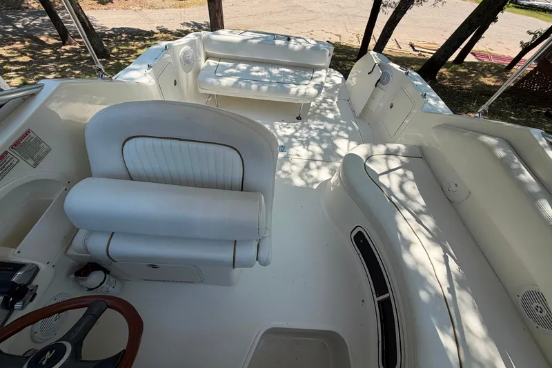 Slide: The Image of Interior view of 2000 Sea Ray 270 Sundancer boat with white seating and steering wheel. - 34
