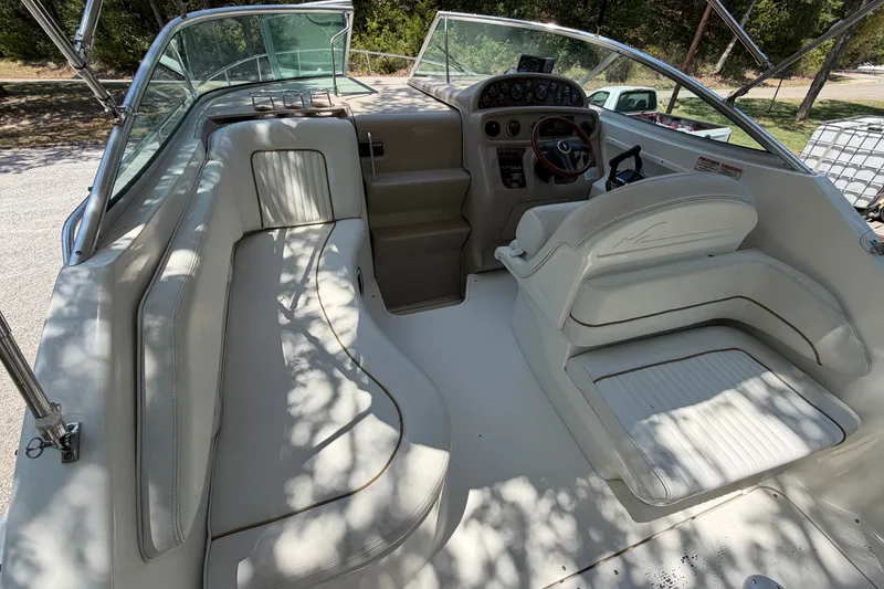 Slide: The Image of 2000 Sea Ray 270 Sundancer boat interior with white seating and steering console. - 30