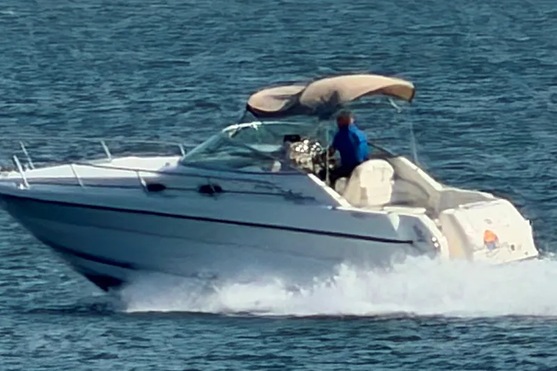 Slide: The Image of 2000 Sea Ray 270 Sundancer cruising on open water, featuring sleek design and canopy. - 10