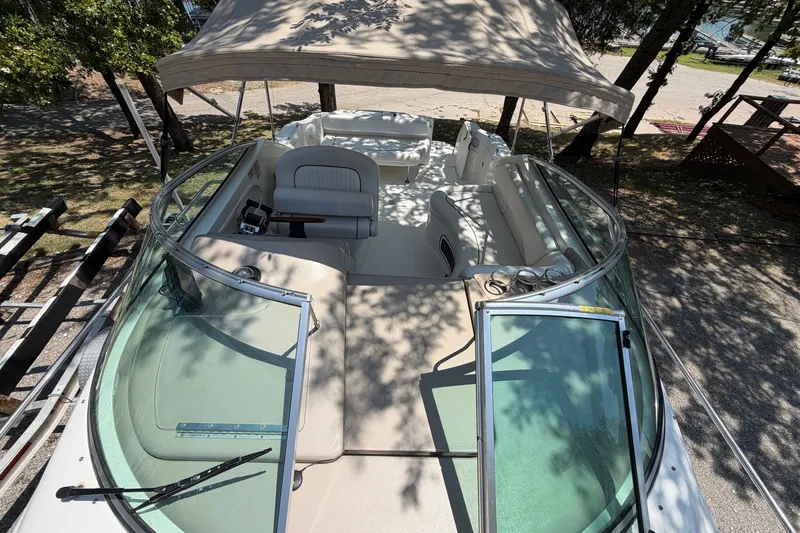 Slide: The Image of 2000 Sea Ray 270 Sundancer boat interior with canopy, docked under trees. - 33
