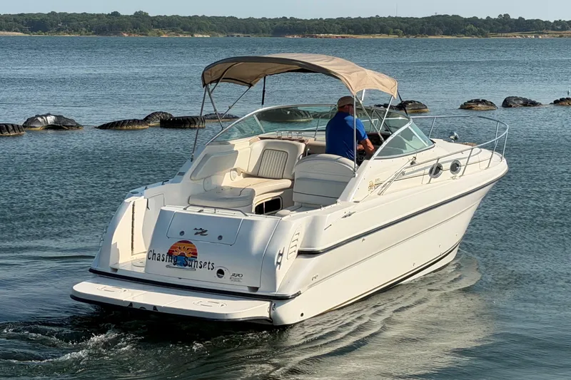 Slide: The Image of 2000 Sea Ray 270 Sundancer boat cruising on a serene lake. - 1