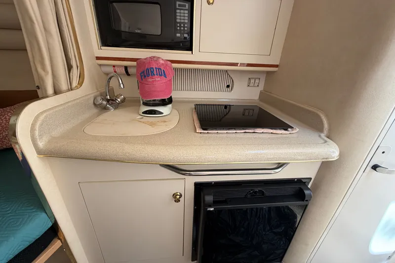 Slide: The Image of Compact kitchenette in a 2000 Sea Ray 270 Sundancer boat with sink, stove, and microwave. - 41