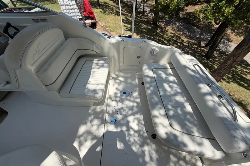 Slide: The Image of 2000 Sea Ray 270 Sundancer boat interior with white seating and outdoor setting. - 29