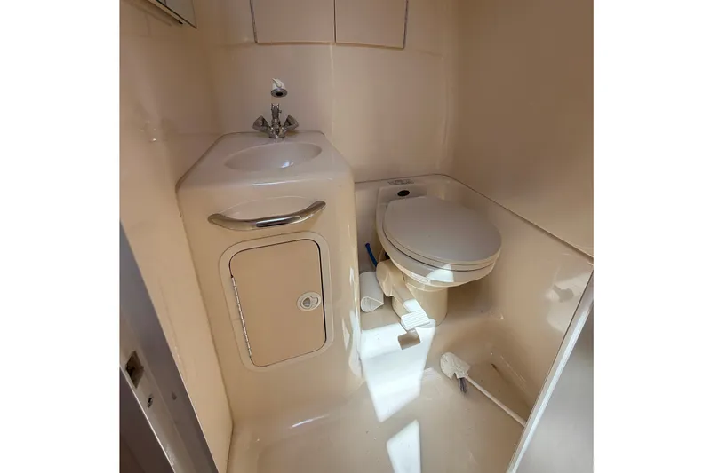 Slide: The Image of Compact bathroom in 2000 Sea Ray 270 Sundancer boat, featuring sink and toilet. - 44
