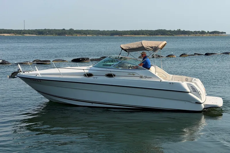 Slide: The Image of 2000 Sea Ray 270 Sundancer boat cruising on a calm lake with a person onboard. - 4