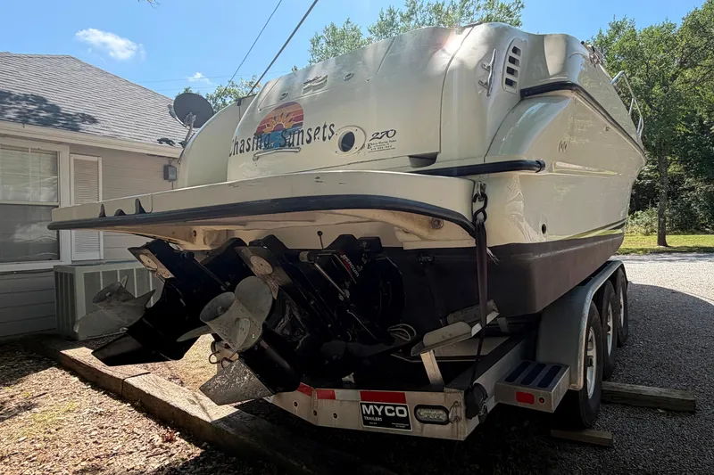 Slide: The Image of 2000 Sea Ray 270 Sundancer boat on trailer, parked near a house. - 16