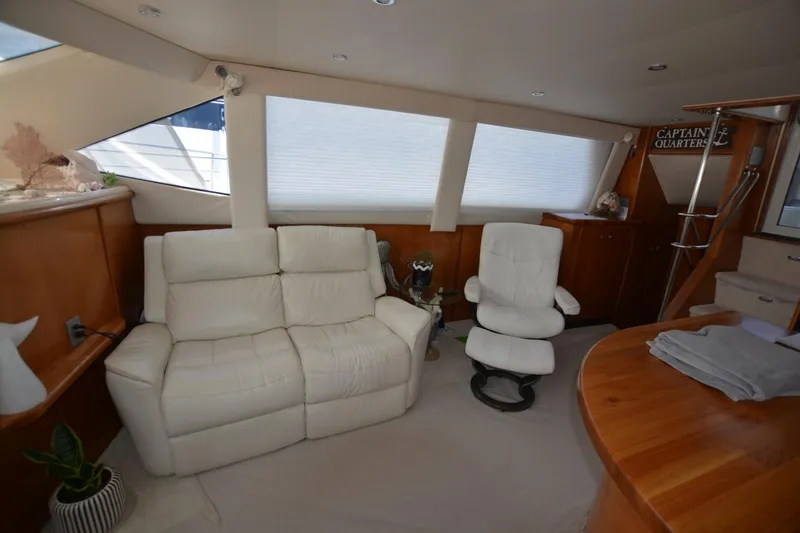 Slide: The Image of Interior of 2000 Carver 504 Cockpit Motor Yacht with white seating and wooden accents. - 10