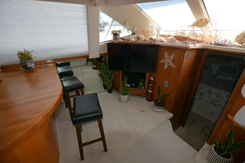 Slide: The Image of Interior of 2000 Carver 504 Cockpit Motor Yacht with bar stools and decorative plants. - 11