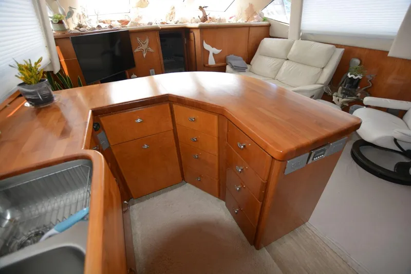 Slide: The Image of Interior of 2000 Carver 504 Cockpit Motor Yacht with wooden cabinetry and seating area. - 13