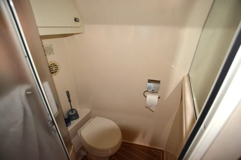 Slide: The Image of Bathroom interior of 2000 Carver 504 Cockpit Motor Yacht, featuring toilet and storage. - 20