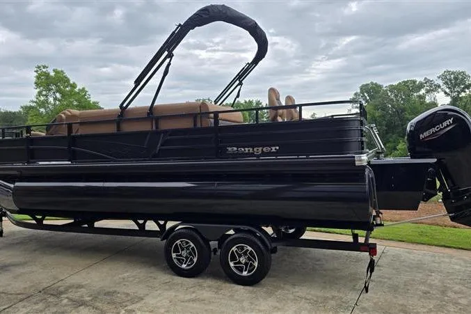 Slide: The Image of 2026 Ranger 223F pontoon boat with Mercury engine on a trailer, parked outdoors. - 3
