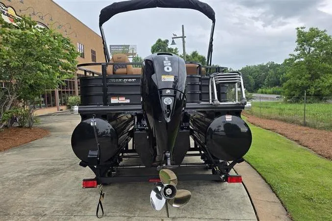 Slide: The Image of 2026 Ranger 223F pontoon boat with powerful outboard motor, parked on a concrete path. - 2