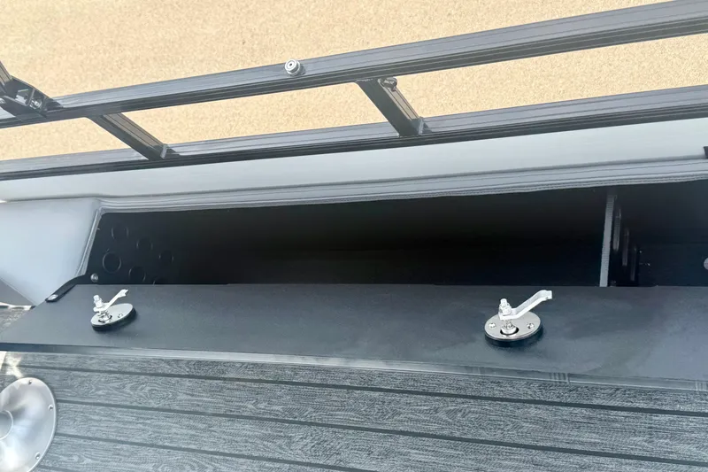 Slide: The Image of Open storage compartment on 2026 Ranger 223FC boat with secure latches. - 14