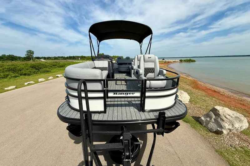 Slide: The Image of 2026 Ranger 223FC pontoon boat parked by a scenic lakeside under a clear sky. - 16