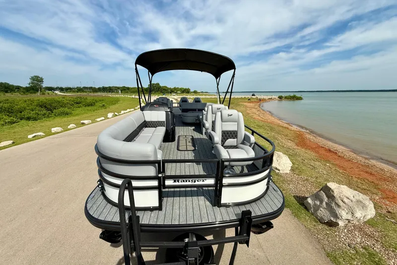 Slide: The Image of 2026 Ranger 223FC pontoon boat parked by a scenic lakeside under a clear sky. - 17
