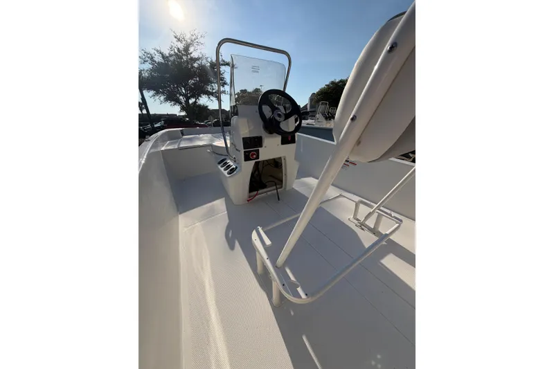 Slide: The Image of 2026 Mako Pro Skiff 17 CC boat interior with steering console and seating. - 2