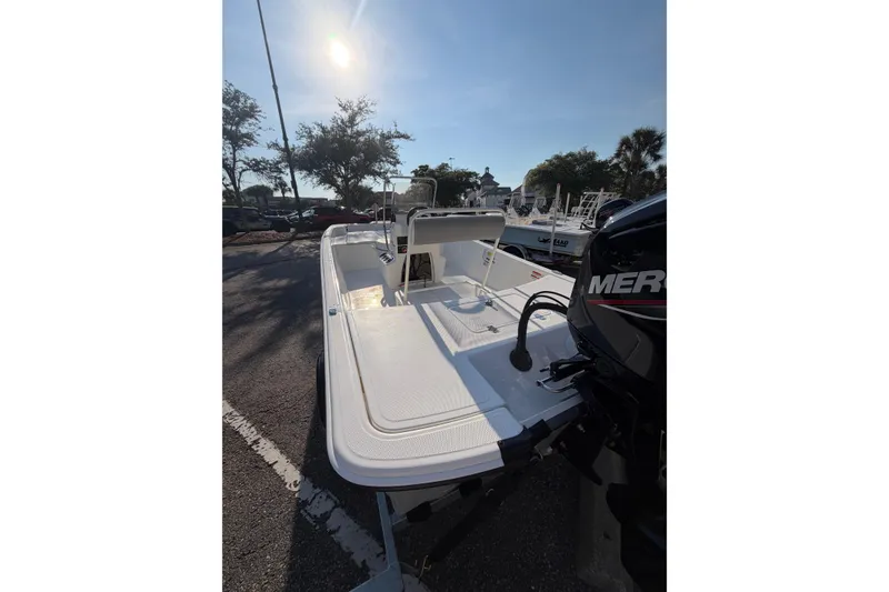 Slide: The Image of 2026 Mako Pro Skiff 17 CC boat with Mercury engine, parked under sunny skies. - 3