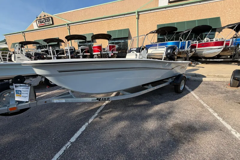 Slide: The Image of 2026 Mako Pro Skiff 17 CC boat displayed at a dealership, surrounded by other boats. - 1