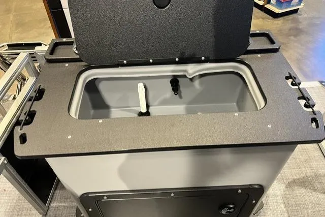 Slide: The Image of 2026 Sun Tracker SportFish 20 DLX livewell with open lid, showcasing interior features. - 100