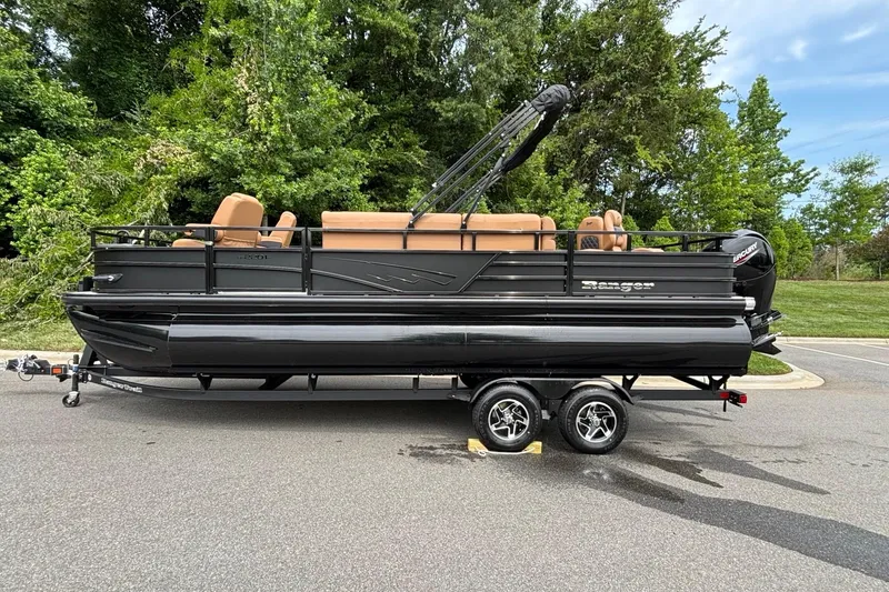 The Image of 2026 Ranger 220F pontoon boat on trailer, parked on road with lush greenery background. - 0