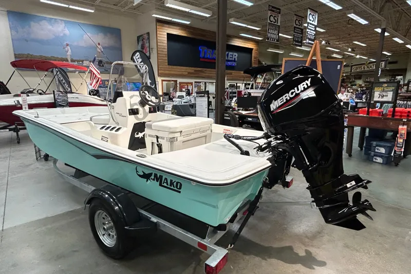 Slide: The Image of 2026 Mako Pro Skiff 15 CC boat with Mercury engine displayed indoors. - 1