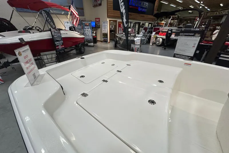 Slide: The Image of 2026 Mako Pro Skiff 15 CC boat on display in showroom with financing sign. - 2