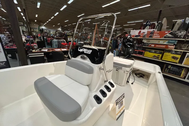 Slide: The Image of 2026 Mako Pro Skiff 15 CC boat displayed in a showroom with accessories. - 3
