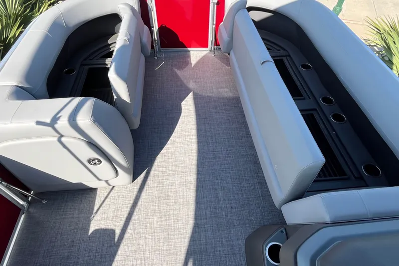 Slide: The Image of 2026 Sun Tracker Party Barge 18 DLX interior with gray seating and cup holders. - 21