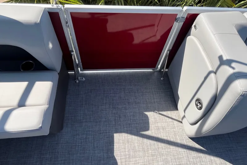 Slide: The Image of 2026 Sun Tracker Party Barge 18 DLX interior with gray seating and red paneling. - 22