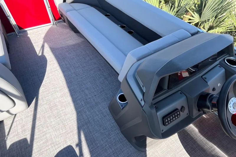 Slide: The Image of 2026 Sun Tracker Party Barge 18 DLX interior with gray seating and steering console. - 19