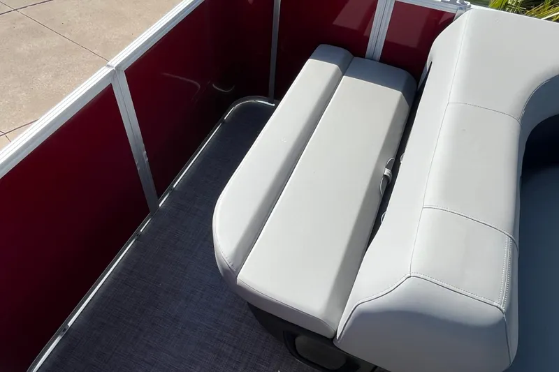 Slide: The Image of 2026 Sun Tracker Party Barge 18 DLX interior seating with red paneling and gray upholstery. - 16