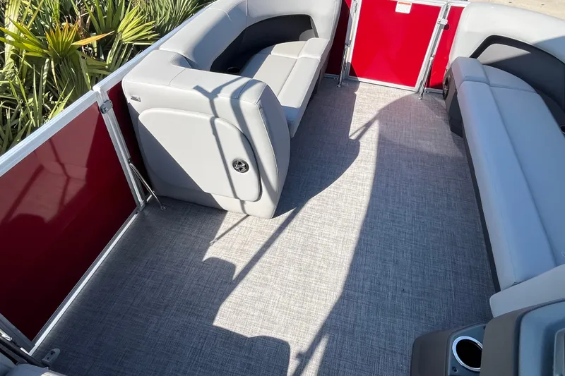 Slide: The Image of 2026 Sun Tracker Party Barge 18 DLX interior with gray seating and red accents. - 20