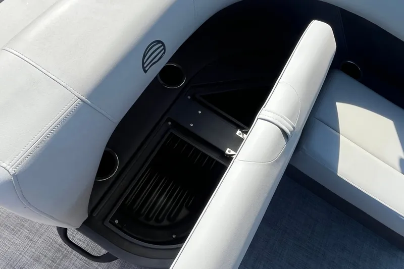 Slide: The Image of 2026 Sun Tracker Party Barge 18 DLX interior seating with storage compartment and cup holders. - 15