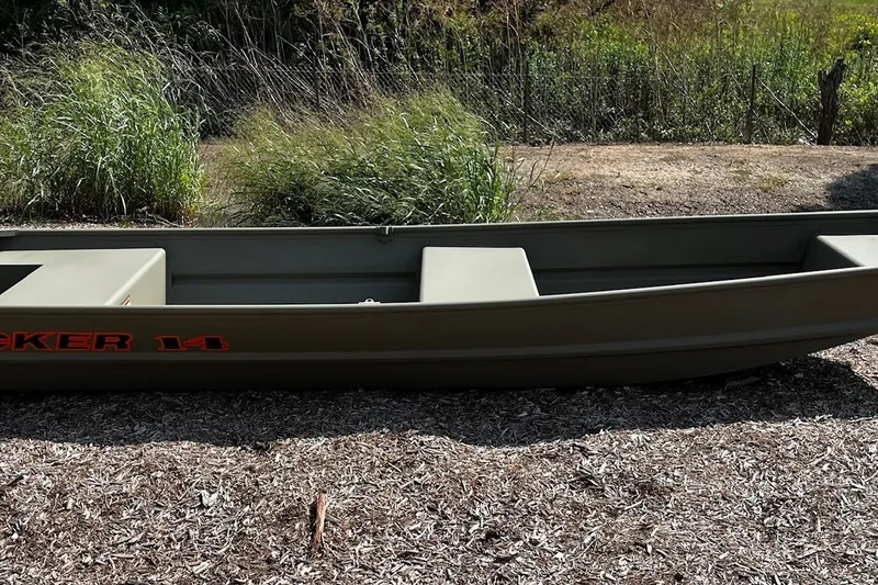 The Image of 2026 Tracker Grizzly 14 Jon boat on dry ground, surrounded by grass and mulch. - 0