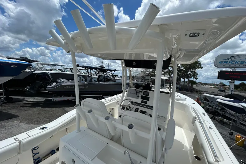Slide: The Image of 2024 Key West 263 FS boat interior with helm, rod holders, and seating under a cloudy sky. - 15