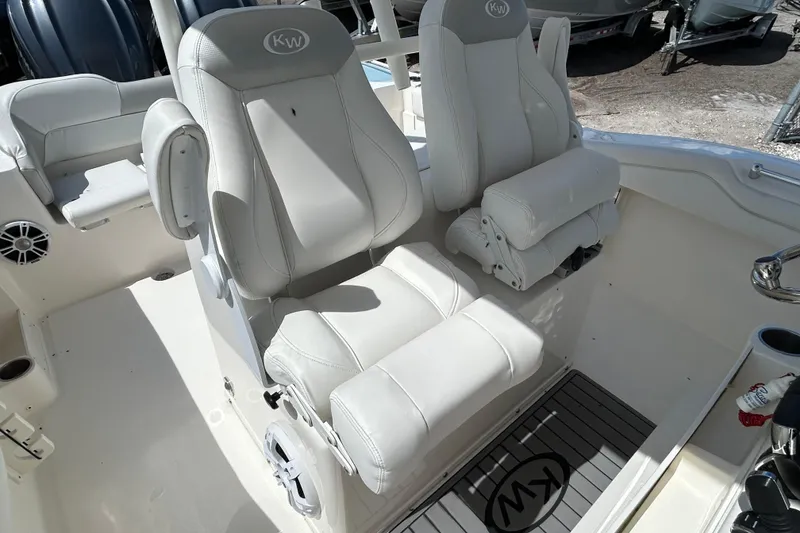 Slide: The Image of 2024 Key West 263 FS boat interior with plush white seating and KW logo mat. - 20