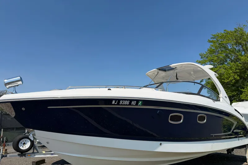 Slide: The Image of 2012 Chaparral 327 SSX boat with sleek design, docked under clear blue sky. - 1