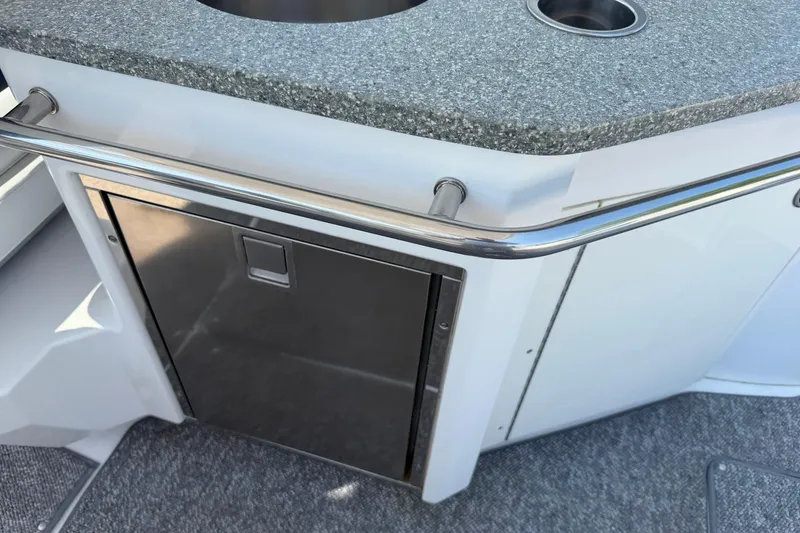 Slide: The Image of 2012 Chaparral 327 SSX boat interior with stainless steel fridge and granite countertop. - 17