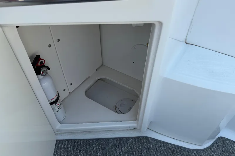 Slide: The Image of Storage compartment with fire extinguisher on 2012 Chaparral 327 SSX boat. - 18