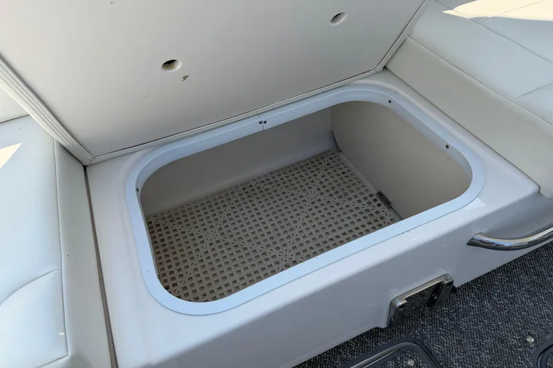 Slide: The Image of Storage compartment on a 2012 Chaparral 327 SSX boat, featuring a white cushioned lid. - 22