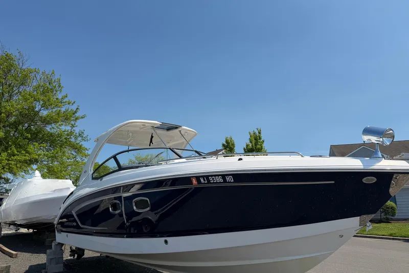 Slide: The Image of 2012 Chaparral 327 SSX boat on display under clear blue sky. - 3