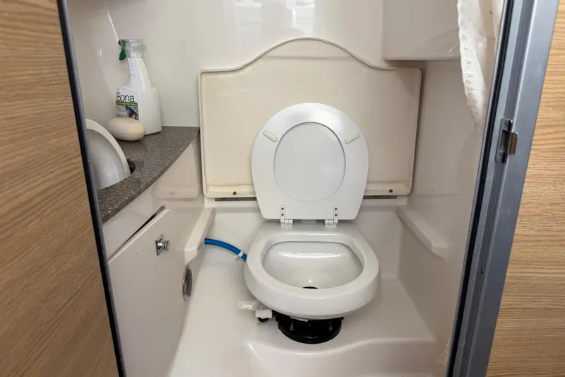 Slide: The Image of 2012 Chaparral 327 SSX boat bathroom with toilet and cleaning supplies. - 39