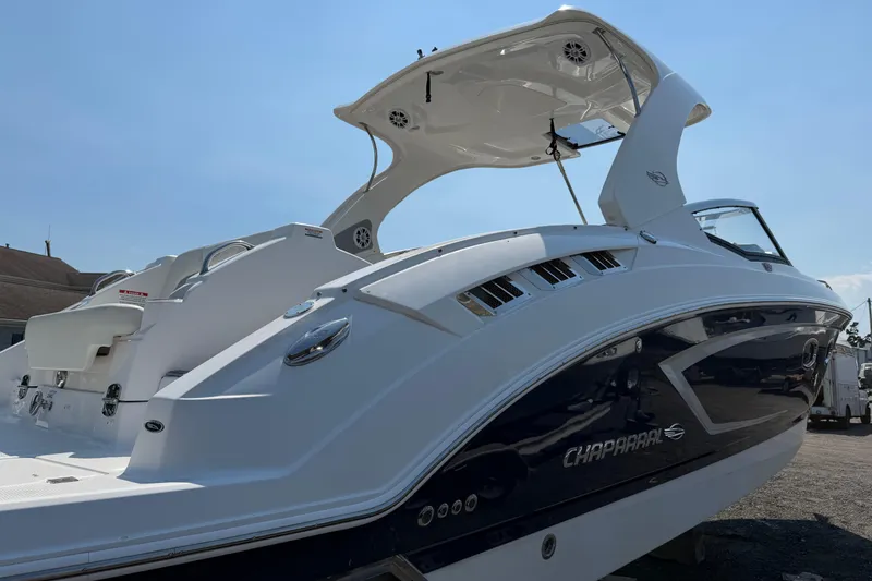 Slide: The Image of 2012 Chaparral 327 SSX boat with sleek design and modern features, docked under clear skies. - 4