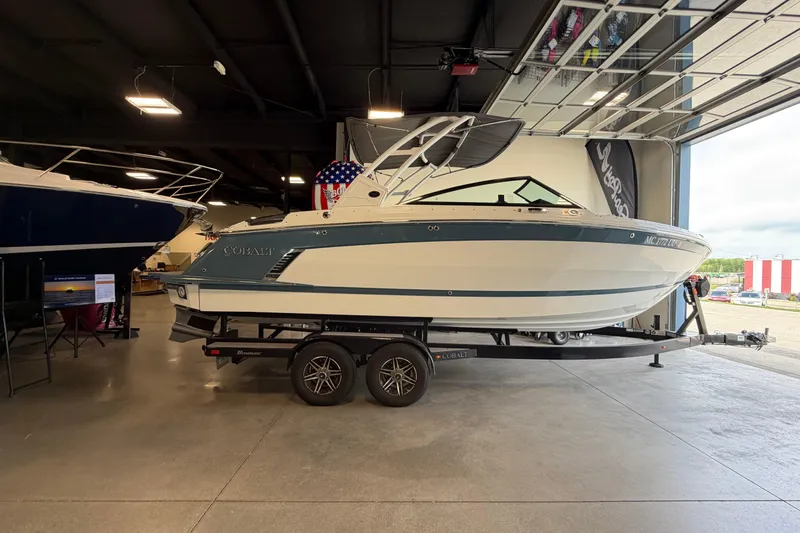 The Image of 2022 Cobalt R6 Surf boat on trailer in showroom, side view. - 1